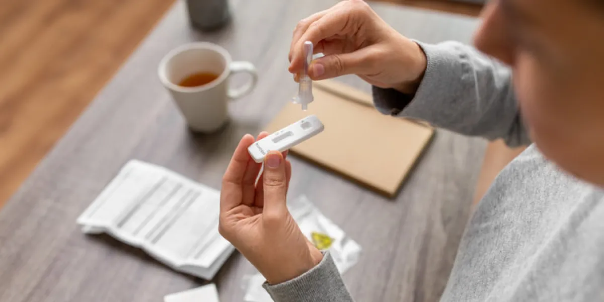 medicine, quarantine and pandemic concept - close up of woman making self testing coronavirus test at home