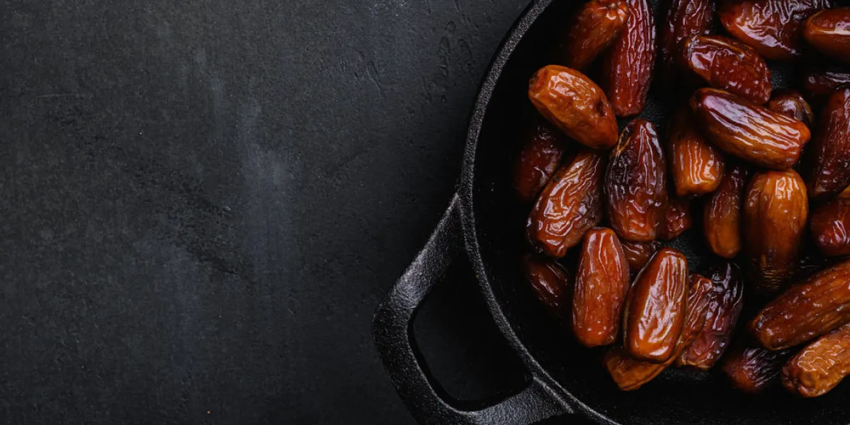 dried date palm fruits, on black dark stone table background, top view flat lay, with copy space for text dried date palm fruits, on black dark stone table background, top view flat lay, with copy space for text