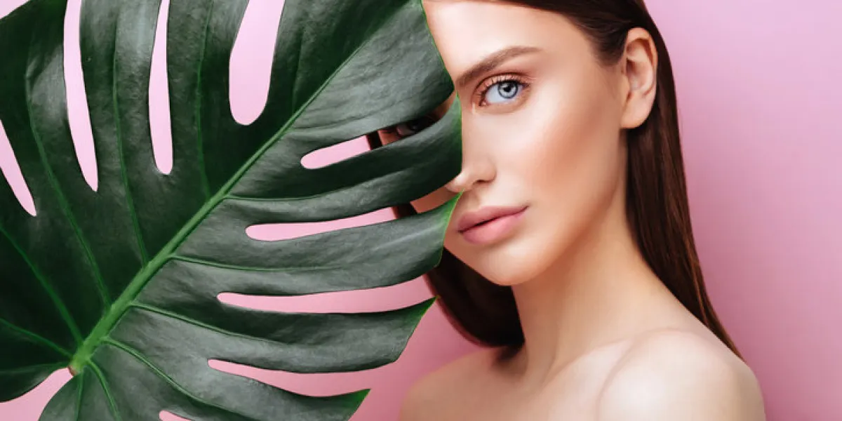 beauty woman with natural green palm leaf portrait, model girl with perfect makeup, natural eyeshadows brunette beautiful fashion model girl face skin care perfect skin on pink background beauty woman with natural green palm leaf portrait, model girl with perfect makeup, natural eyeshadows brunette beautiful fashion model girl face skin care perfect skin on pink background