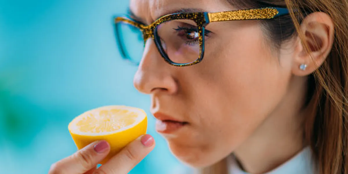 anosmia or smell blindness, loss of the ability to smell, one of the possible symptoms of covid-19, infectious disease caused by corona virus woman trying to sense smell of a lemon anosmia or smell blindness, loss of the ability to smell, one of the possible symptoms of covid-19, infectious disease caused by corona virus woman trying to sense smell of a lemon