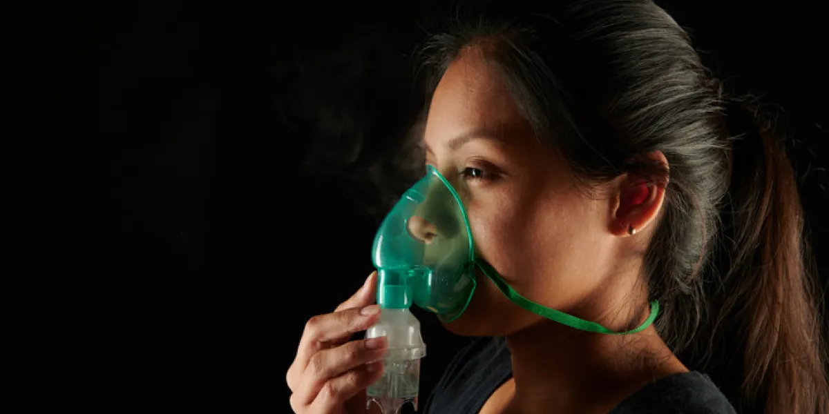 woman face with nebulizer mask isolated on black background woman face with nebulizer mask isolated on black background
