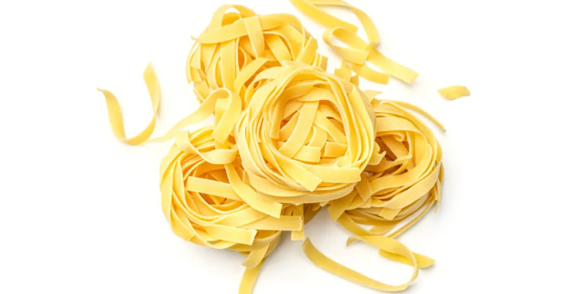 italian pasta fettuccine nest isolated on white background top view italian pasta fettuccine nest isolated on white background top view
