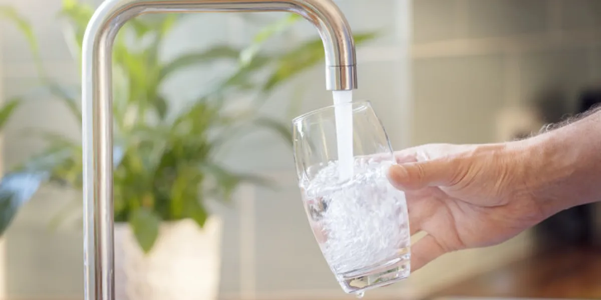 filling up a glass with clean drinking water from kitchen faucet filling up a glass with clean drinking water from kitchen faucet