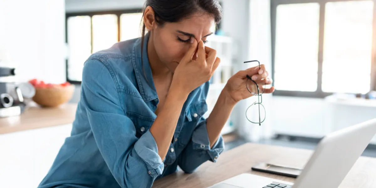 shot of stressed business woman working from home on laptop looking worried, tired and overwhelmed