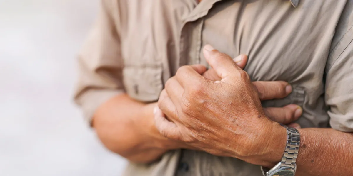 close-up of an elderly man's hand held his chest in pain concept of heart disease close-up of an elderly man's hand held his chest in pain concept of heart disease