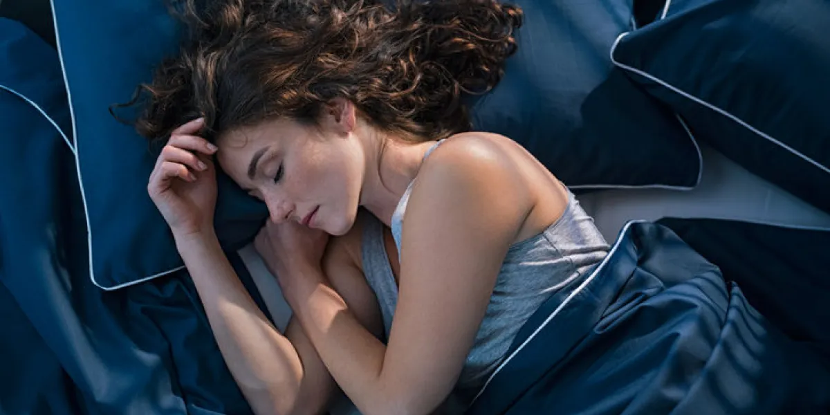 top view of young woman sleeping on side in her bed at night beautiful girl sleeping profoundly and dreaming at home with blue blanket high angle view of woman asleep with closed eyes top view of young woman sleeping on side in her bed at night beautiful girl sleeping profoundly and dreaming at home with blue blanket high angle view of woman asleep with closed eyes