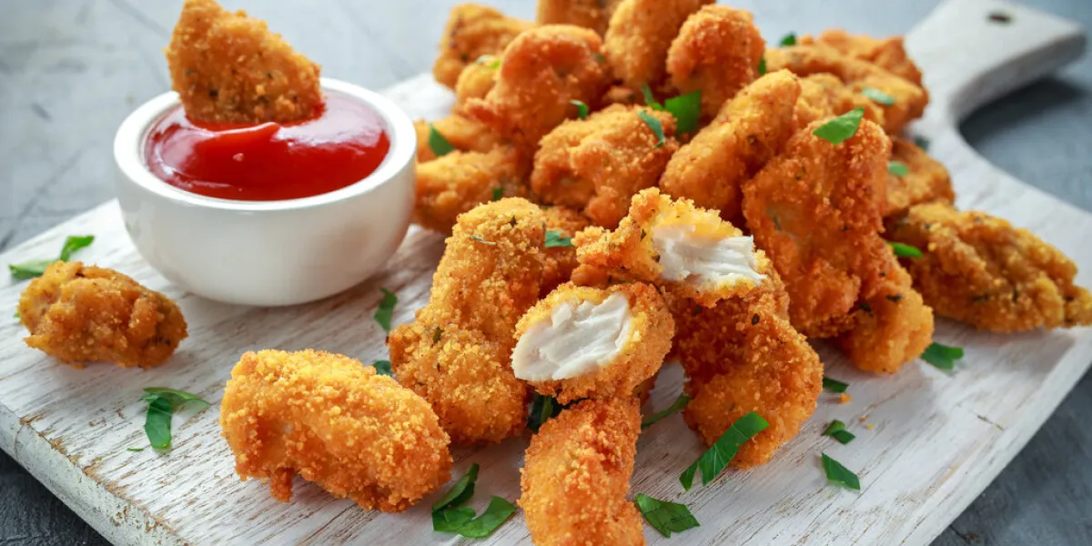 fried crispy chicken nuggets with ketchup on white board