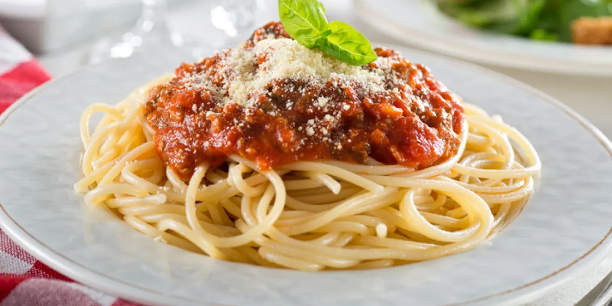 a plate of delicious spaghetti bolognese with meat sauce and fresh basil
