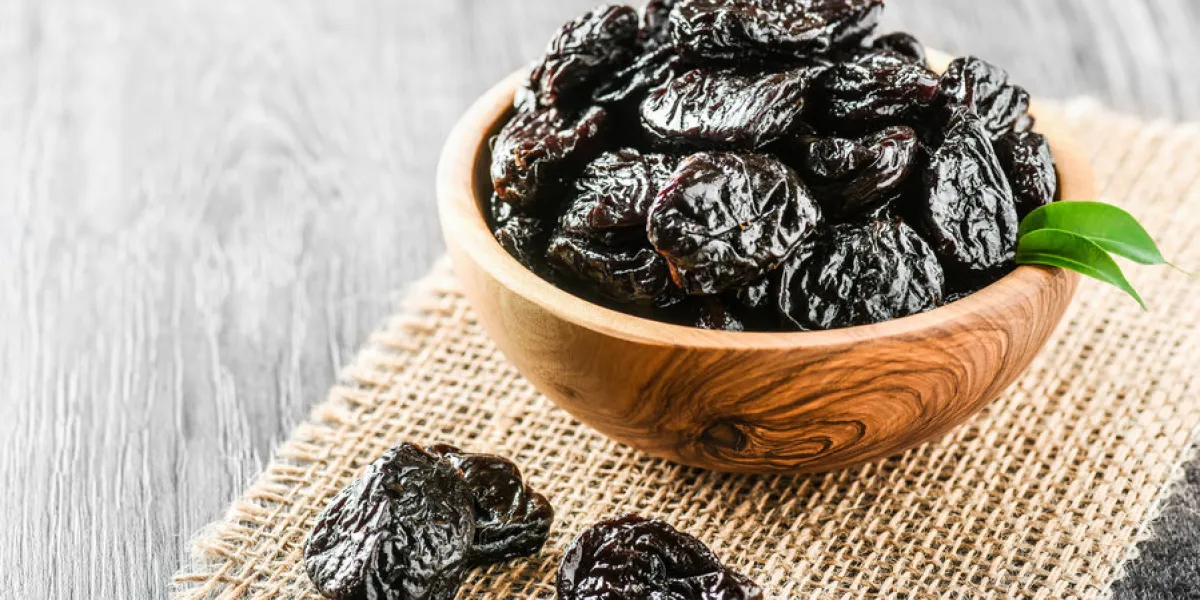 fresh prunes in wooden bowl prunes on stone dark table prunes healthy food dried plums
