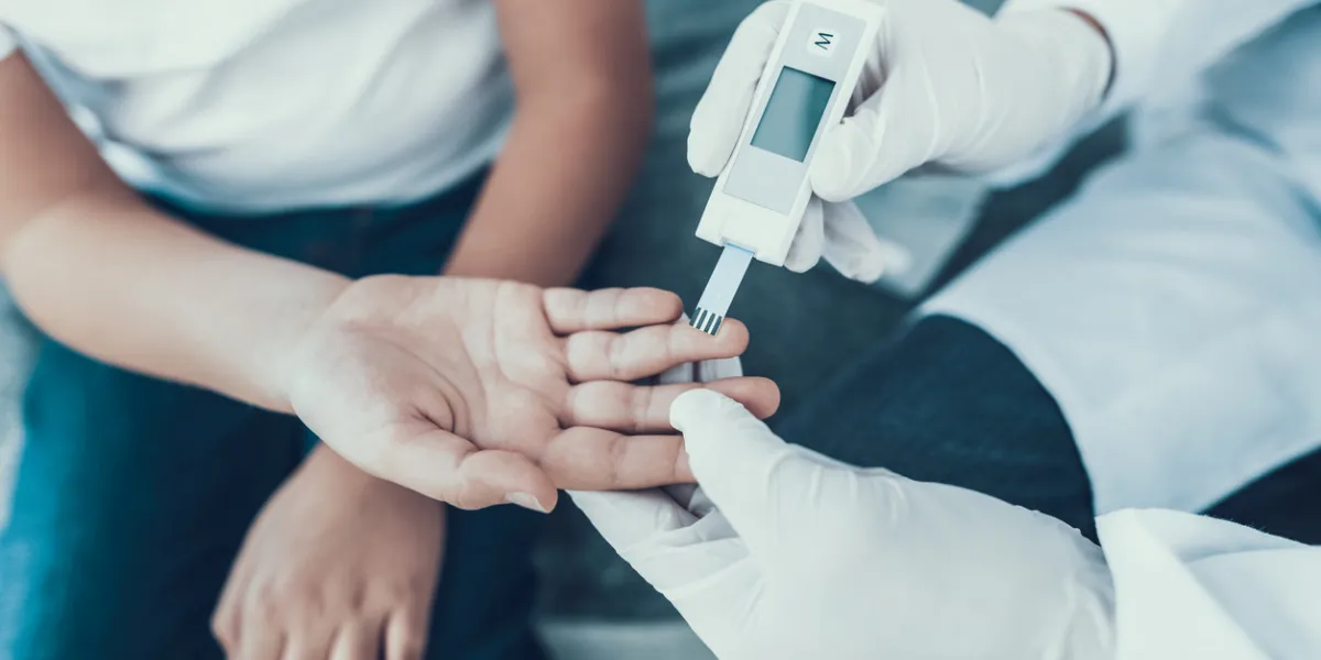 doctor taking blood sample from boy's finger diabetes concept sugar in blood healthcare concept young man in uniform white coat medical equipment boy in clinic glucometer in hand doctor taking blood sample from boy's finger diabetes concept sugar in blood healthcare concept young man in uniform white coat medical equipment boy in clinic glucometer in hand