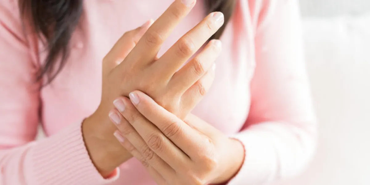 closeup woman sitting on sofa holds her wrist hand injury, feeling pain health care and medical concept closeup woman sitting on sofa holds her wrist hand injury, feeling pain health care and medical concept
