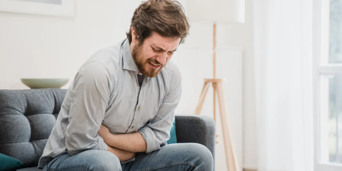 guy feeling unwell with a stomach ache while sitting at home guy feeling unwell with a stomach ache while sitting at home