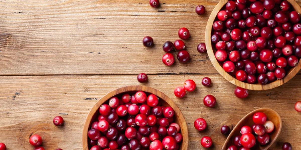 cranberry in wooden bowl on rustic table from above cranberry in wooden bowl on rustic table from above