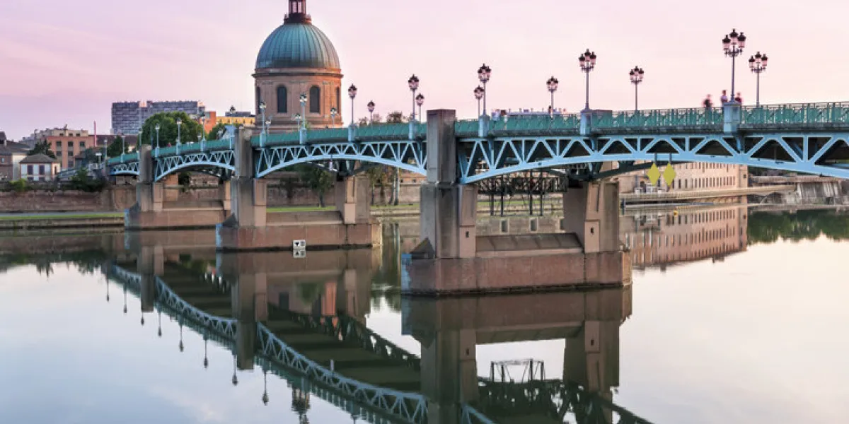 saint-pierre bridge reflecting in garonne river and dome de la grave at sunset in toulouse, france saint-pierre bridge reflecting in garonne river and dome de la grave at sunset in toulouse, france