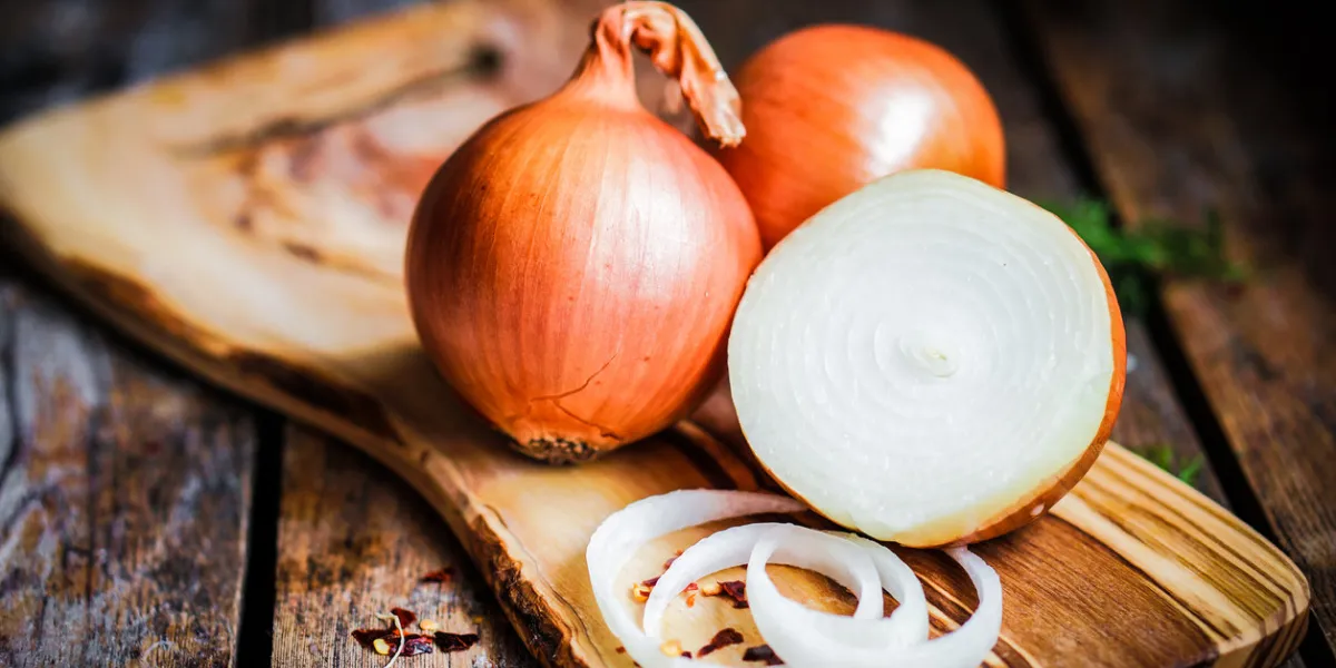 golden onions on rustic wooden background