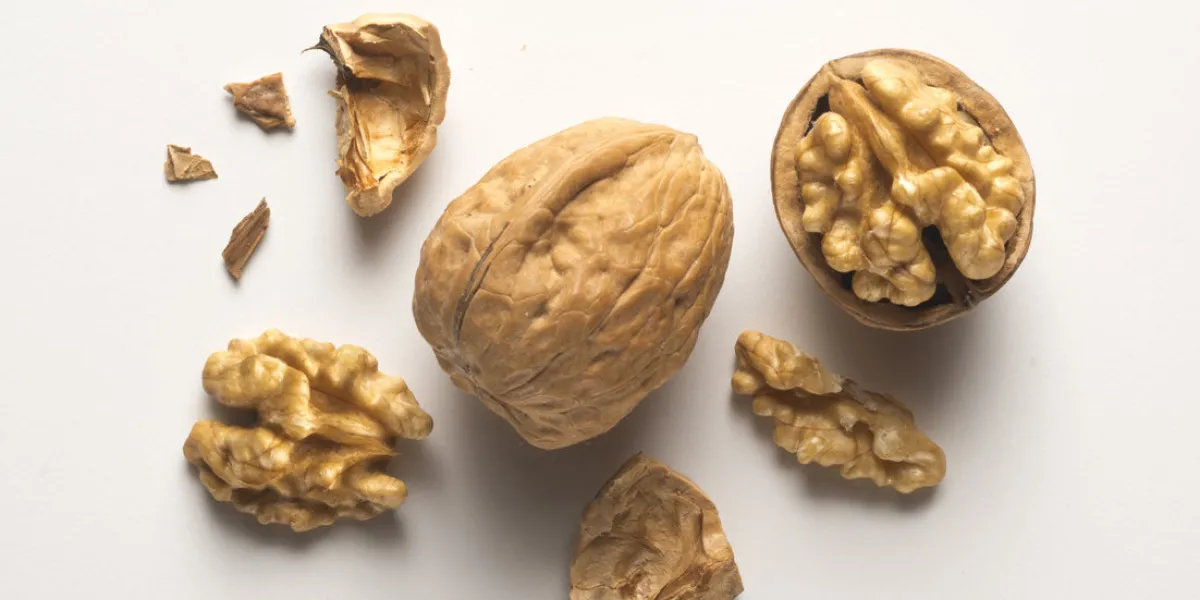 a whole walnut, an open walnut and other pieces a whole walnut, an open walnut and other pieces