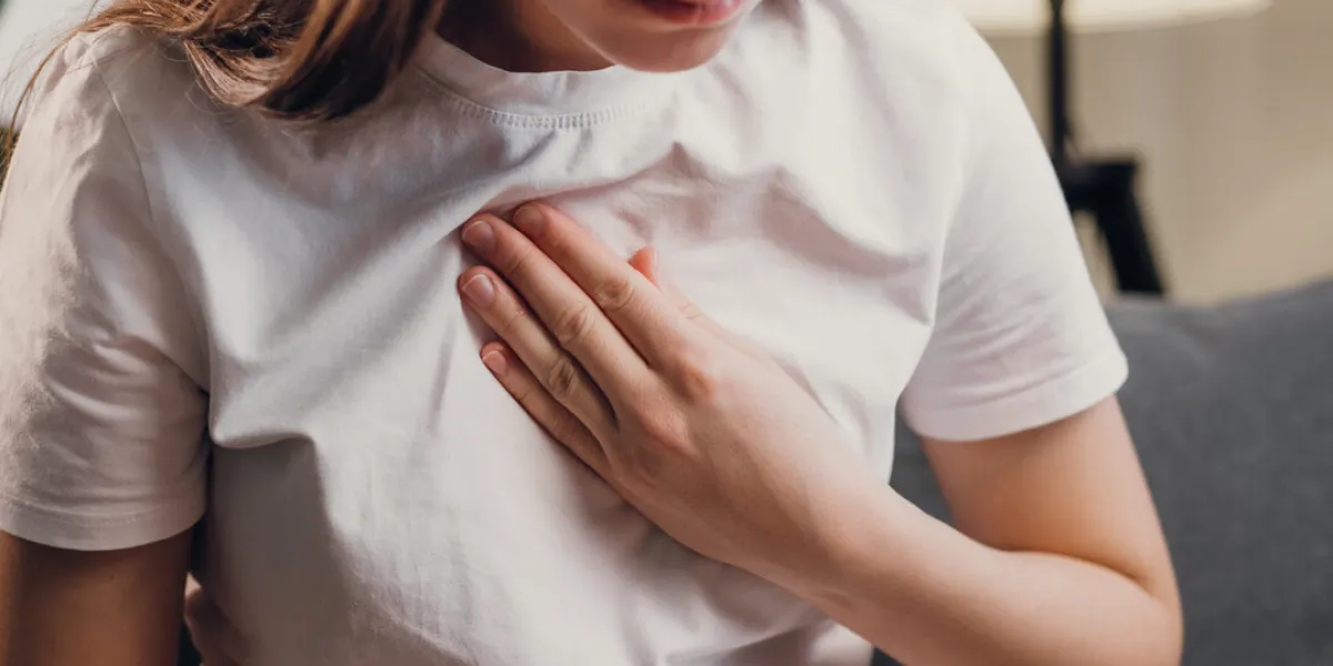 young unhealthy female sit on couch having difficulty breathing pain of heart, touches his chest with hand trouble breathing, chest pain heart attack, thoracic osteochondrosis, panic attack concept young unhealthy female sit on couch having difficulty breathing pain of heart, touches his chest with hand trouble breathing, chest pain heart attack, thoracic osteochondrosis, panic attack concept