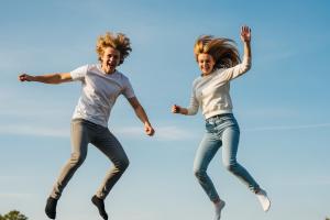 un jeune homme et une jeune femme qui sautent sur un trampoline