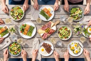 Prompt 2: Un groupe d'amis partageant un déjeuner convivial en terrasse sous un soleil printanier, d