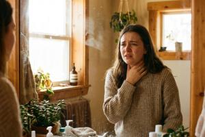 photo réaliste et chaleureuse. Une jeune femme se regarde dans la glace de la salle de bains. Elle a