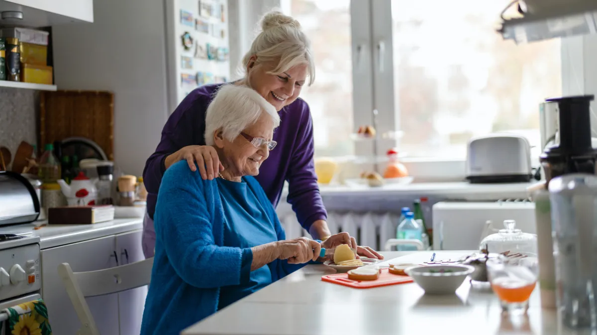 personne âgée et son enfant adulte dans une cuisine lumineuse