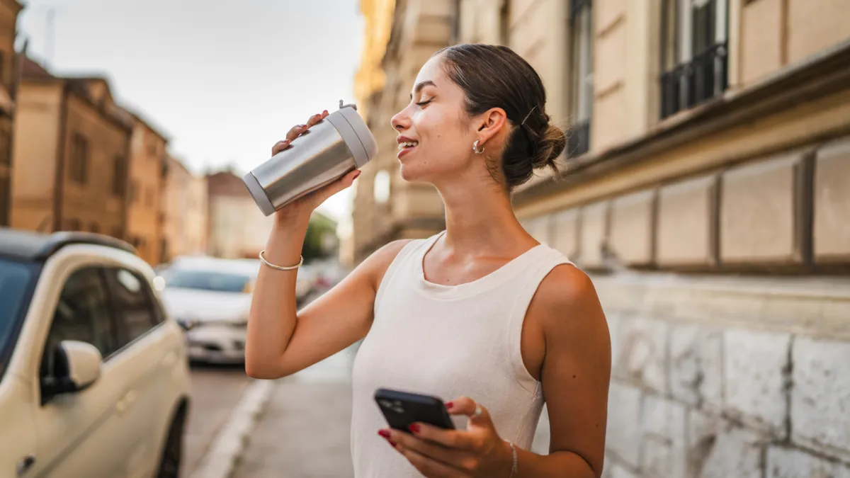 femme buvant avec une gourde alu