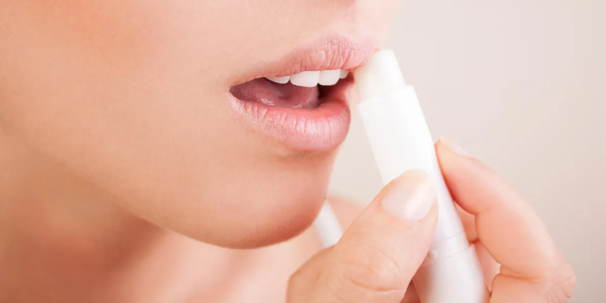 woman applying balsam on lips