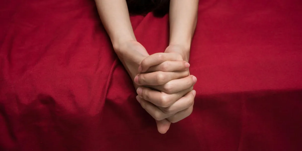 woman hands on bed sheet