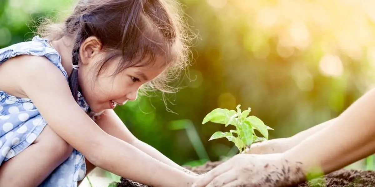 asian little girl and parent planting young tree on black soil together as save world concept in vintage color tone