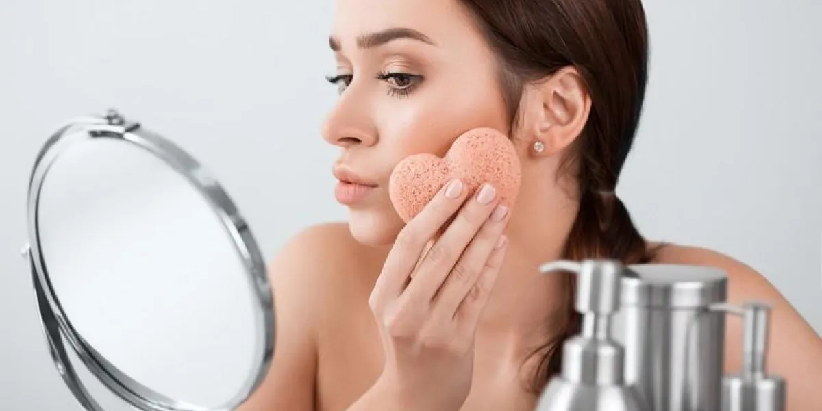beautiful woman make a facial treatment with a sponge in the mirror beautiful woman make a facial treatment with a sponge in the mirror