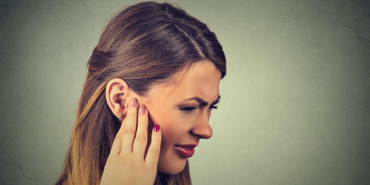 acouphène closeup côté profil malade jeune femme ayant la douleur de l'oreille touchant sa tête douloureuse isolée sur fond gris acouphène closeup côté profil malade jeune femme ayant la douleur de l'oreille touchant sa tête douloureuse isolée sur fond gris