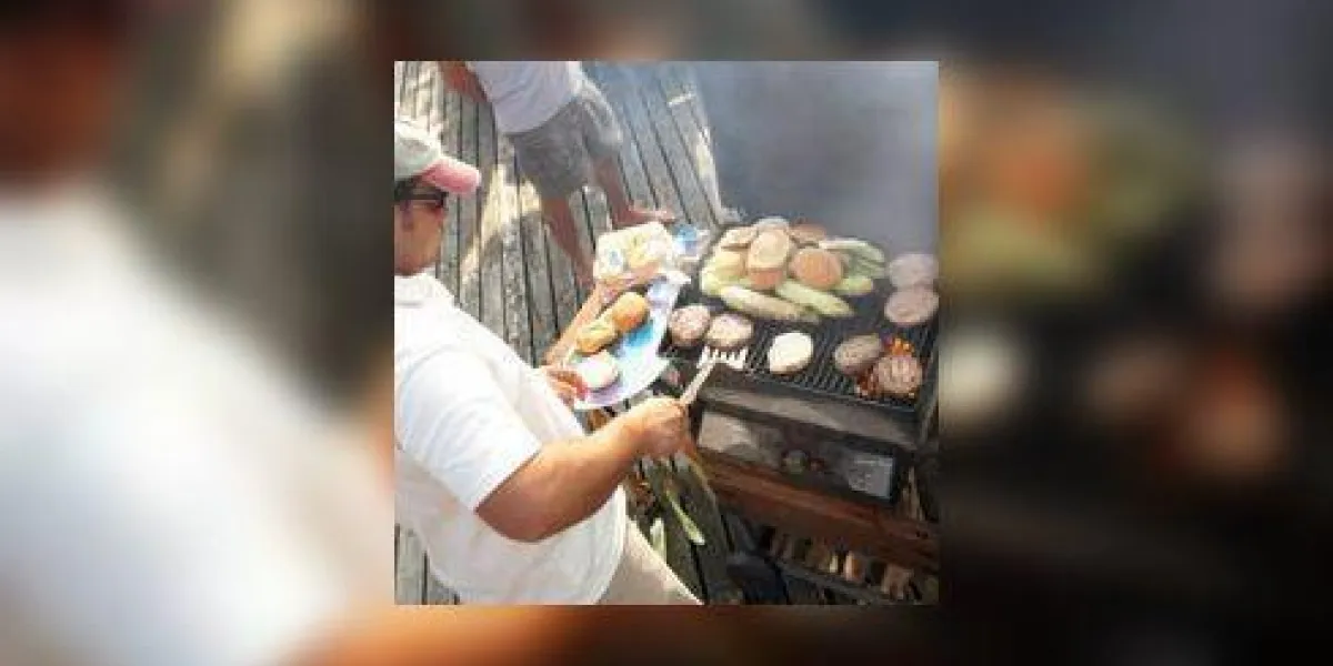groupe d'hommes ayant barbecue sur le pont, la fumée qui monte au premier plan groupe d'hommes ayant barbecue sur le pont, la fumée qui monte au premier plan