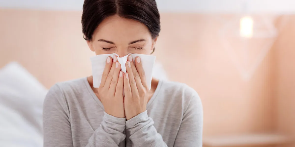 sneezing woman pretty young woman standing in her room and sneezing with her eyes closed sneezing woman pretty young woman standing in her room and sneezing with her eyes closed