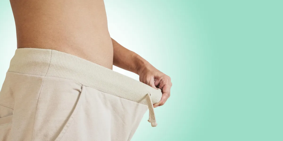 asian guy pulling warm pant, concept of sexuality problem or weight loosing asian guy pulling warm pant, concept of sexuality problem or weight loosing