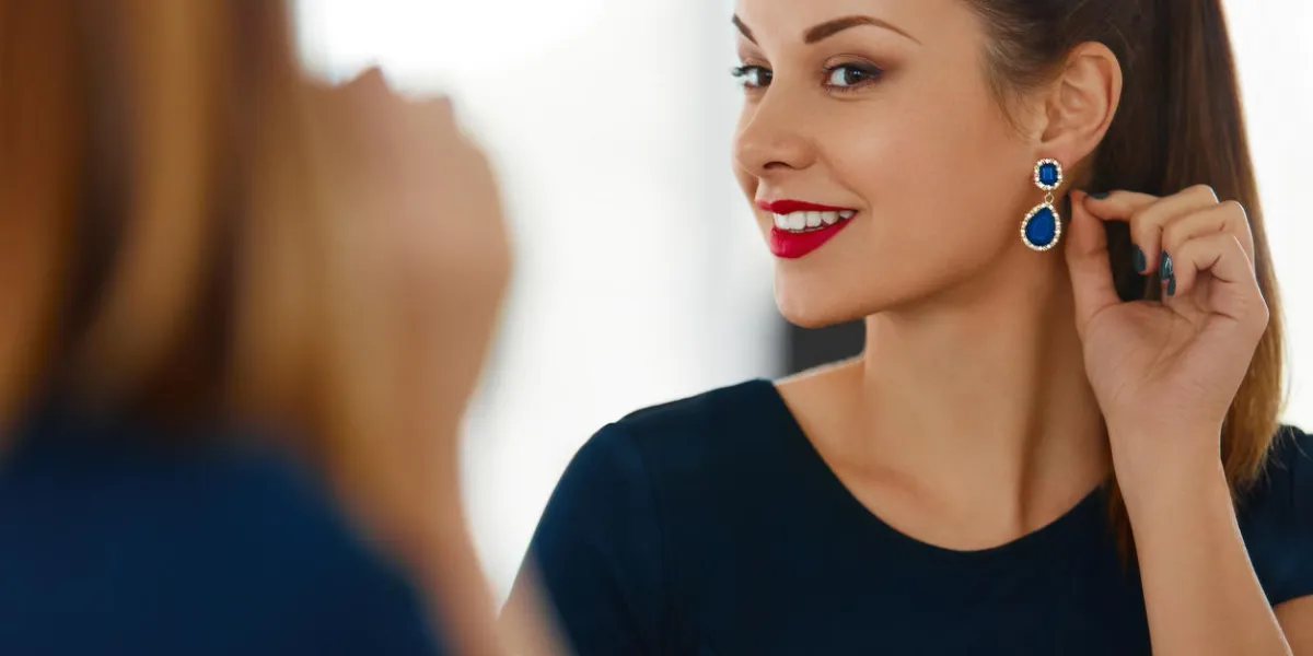 fashion woman portrait beautiful elegant successful female with evening make-up wearing luxurious blue dress smiling in the mirror jewelry and beauty wellbeing, luxury lifestyle