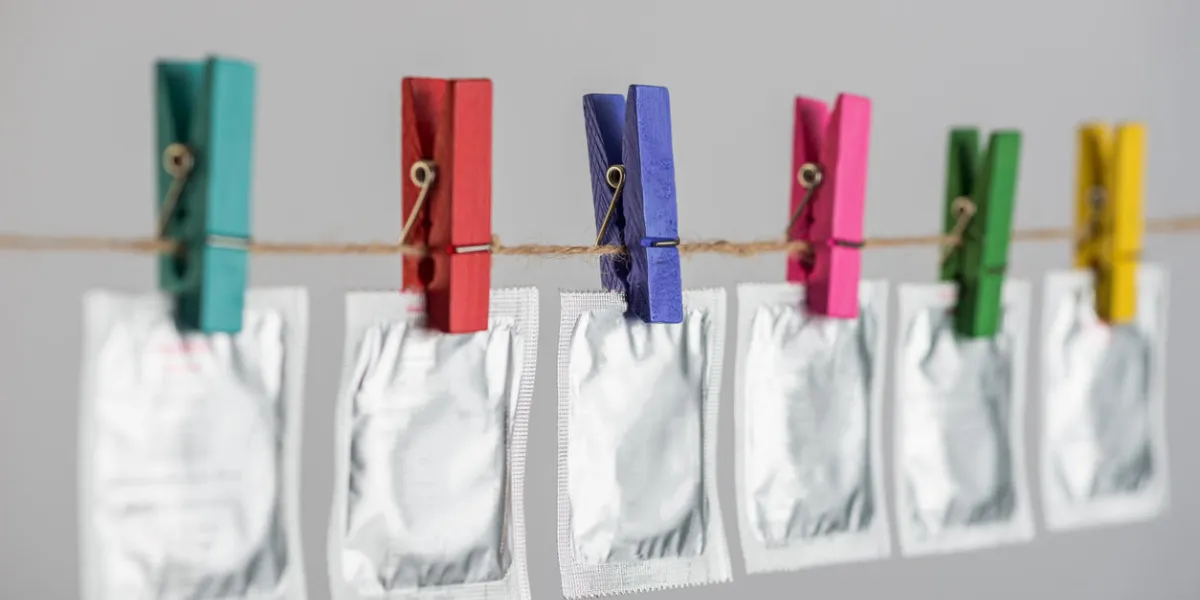 condoms hanging on the rope on gray background