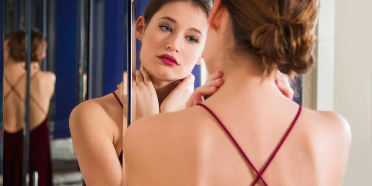 portrait of beautiful young woman in red dress with naked back, standing in front of the mirror, beauty fashion concept, blurred background portrait of beautiful young woman in red dress with naked back, standing in front of the mirror, beauty fashion concept, blurred background
