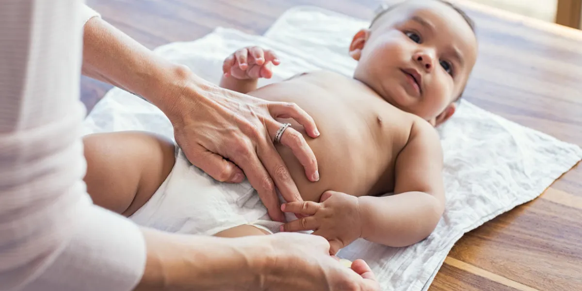 mother hands changing baby nappy mother putting diaper on her hispanic son lying in nursery close up of mother giving baby diaper change at home mother hands changing baby nappy mother putting diaper on her hispanic son lying in nursery close up of mother giving baby diaper change at home