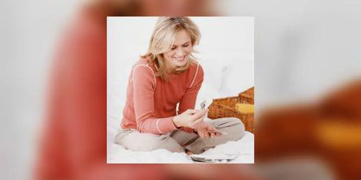 femme assise croix jambes sur un lit, en regardant les photographies