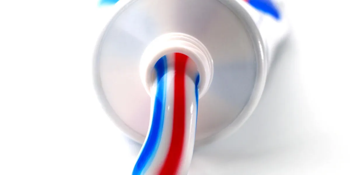 tricolor toothpaste in plastic tube, closeup, shallow depth of field