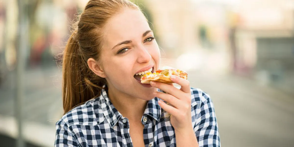 mode de vie adolescent - jeune femme mangeant une pizza en plein air dans la rue mode de vie adolescent - jeune femme mangeant une pizza en plein air dans la rue
