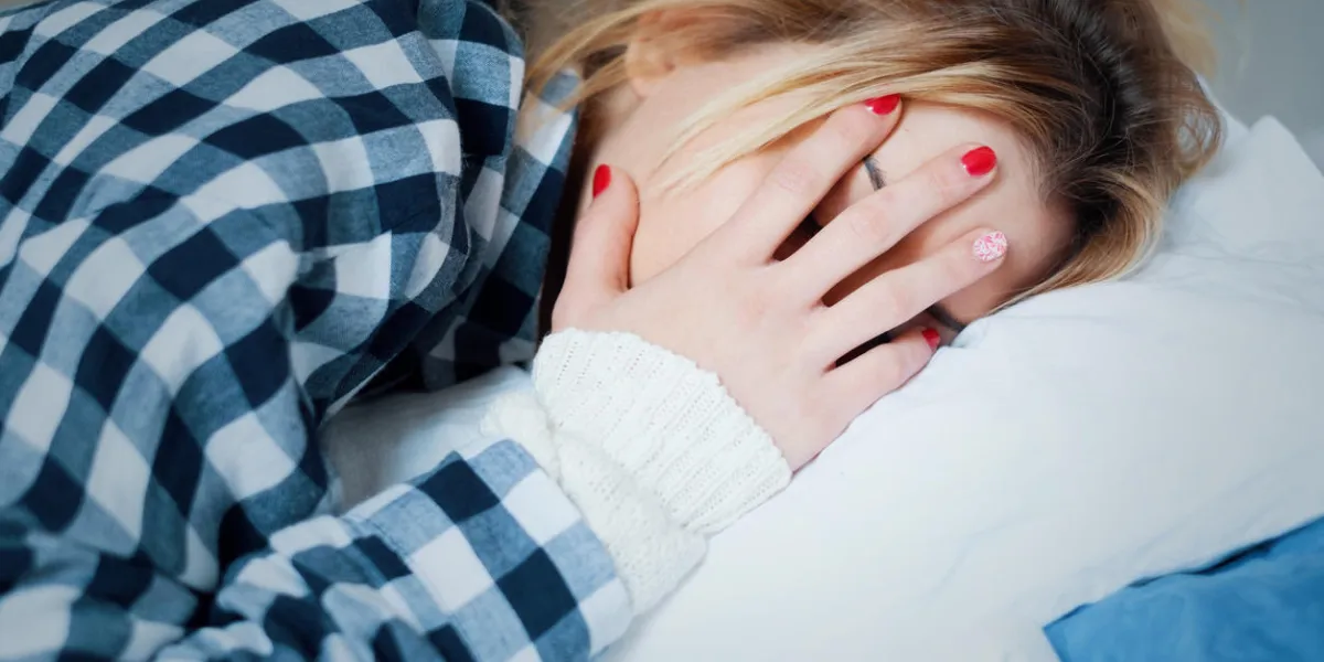 young woman crying in bed after domestic violence at home young woman crying in bed after domestic violence at home