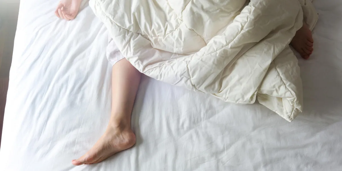 bare feet of a young woman on white bed bare feet of a young woman on white bed