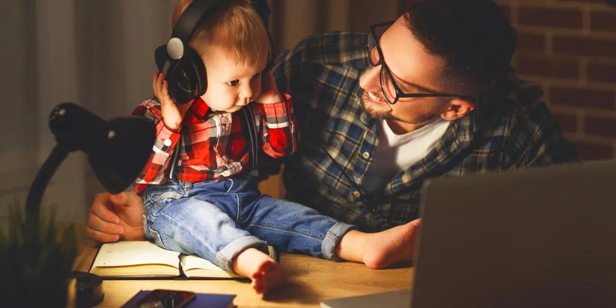 family father and son baby listening to music with headphones in the dark night