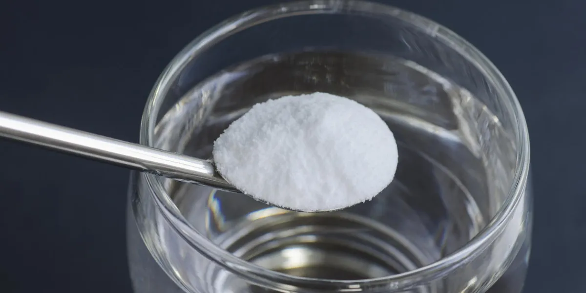 spoon of baking soda over glass of water spoon of baking soda over glass of water