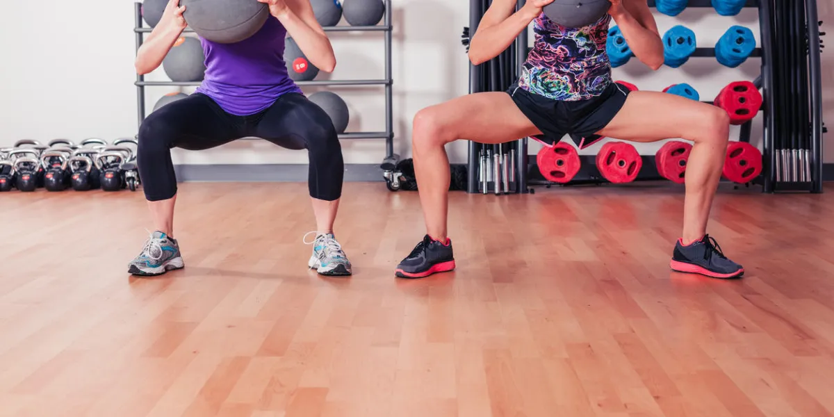 deux jeunes femmes travaillent avec des balles de médecine dans la salle de gym