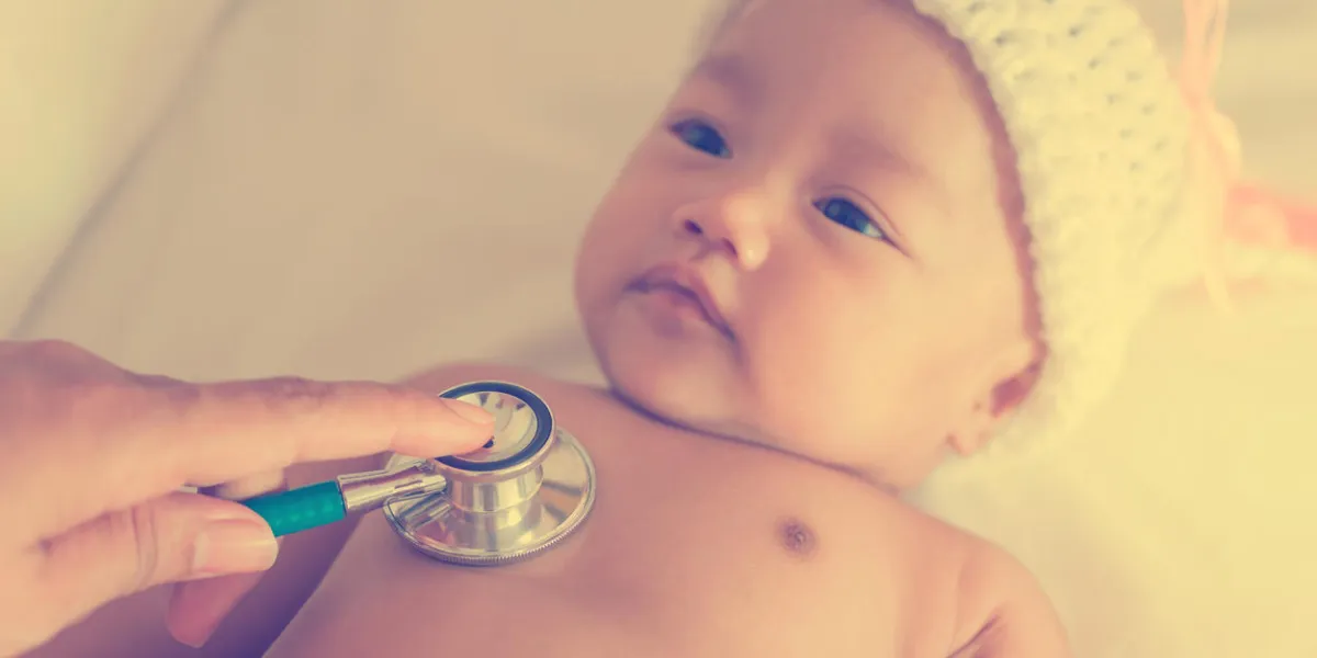 pediatric doctor exams newborn baby girl with stethoscope in hospital vintage style