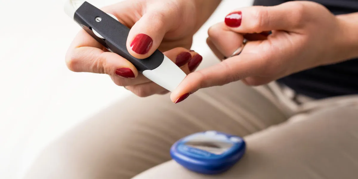 person using diabetes kit on her finger