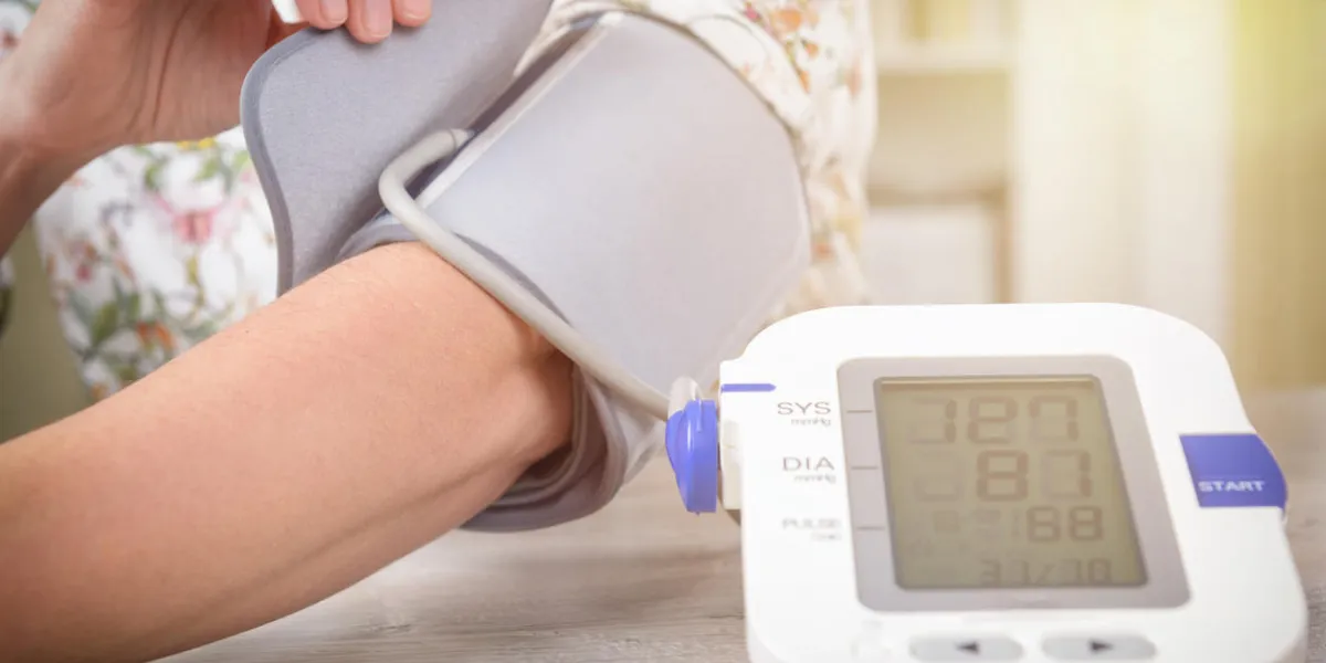 women's hand with blood pressure monitor cuff checking blood pressure at home concept women's hand with blood pressure monitor cuff checking blood pressure at home concept