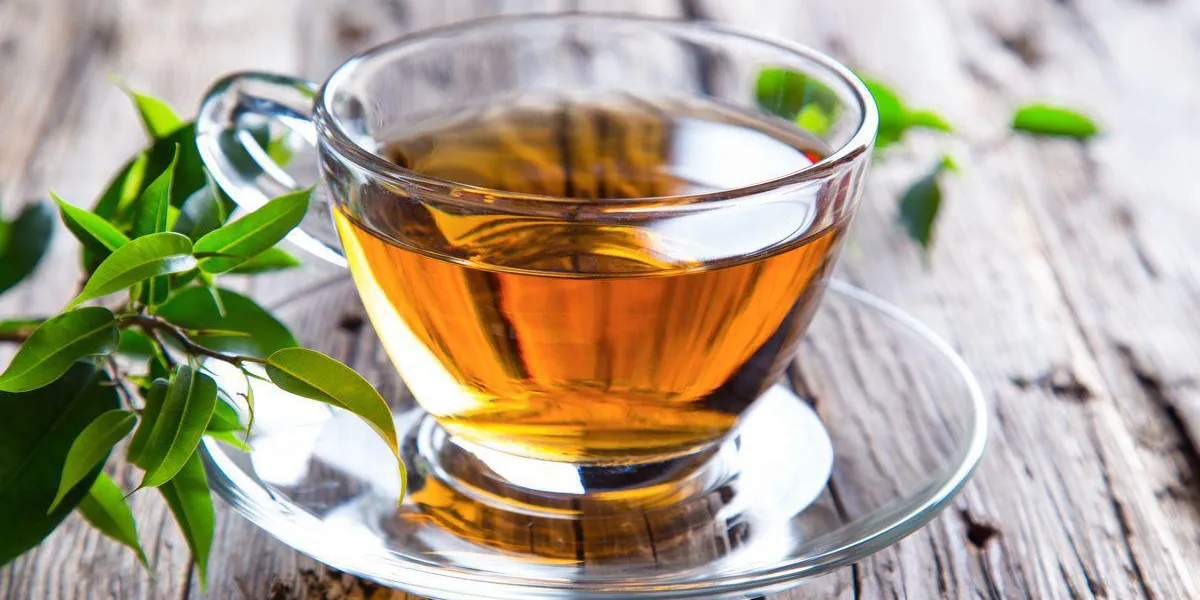 tasse transparente de thé vert sur fond en bois